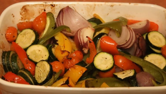 Roasted Mediterranean vegetables are presented in a container for tasting.