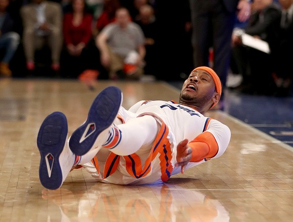 Carmelo Anthony of the New York Knicks falls as he follows through on a shot in the fourth quarter against the Charlotte Hornets at Madison Square Garden on January 27, 2017 in New York City. 