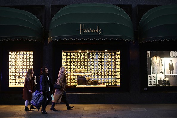 Shoppers walk past Harrods department store.