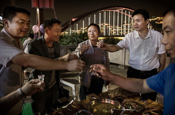Chinese men toast each other while drinking thier locally made wine called baijiu at dinner on the Chishui River, on Sept. 23, 2016 in Maotai, Guizhou Province, China.