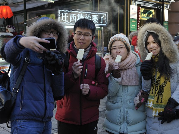 People enjoy popsicle at central street in Harbin City. Rise in consumer spending drives economic growth.