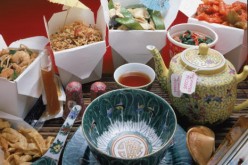 A display of Chinese take-out food and appropriate serving and eating items.