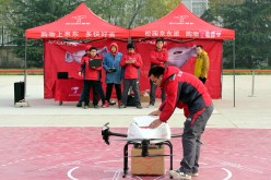 A delivery man carries express parcels out of an unmanned delivery helicopter of JD.com.