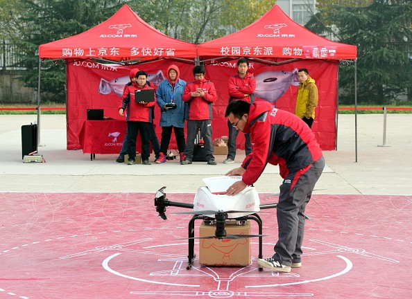 A delivery man carries express parcels out of an unmanned delivery helicopter of JD.com.