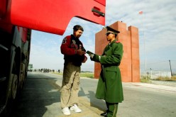 A police officer checks a truck driver's passport at Horgas land port between China and Kazakhstan, Oct. 17, 2005, in Horgas, Xinjiang Uyghur Autonomous Region, China.