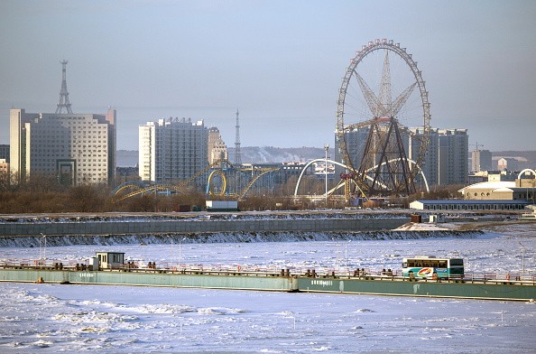 A distant view of an amusement park in Heihe, Heilongjian, China, on the southern bank of the Amur River, as seen from Blagoveshchensk, Amur Region, Russia.