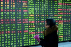 An investor watches the electronic board at a stock exchange hall on Feb. 3, 2017 in Hangzhou, Zhejiang Province. 