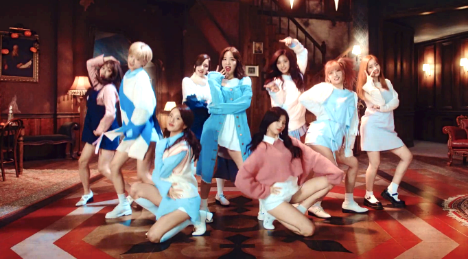 Members of the girl group, TWICE, in a still from the MV of their hit track, "TT."