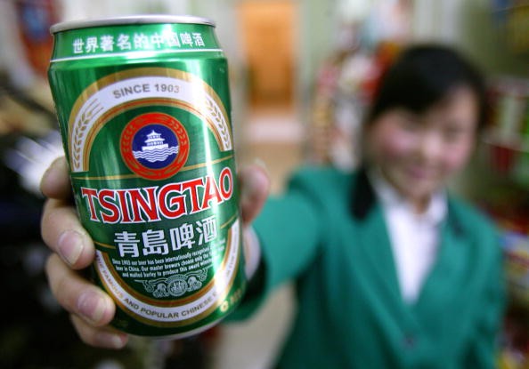 A can of Tsingtao beer is displayed by a clerk at a food market.