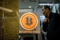 A man walks out of a shop displaying a bitcoin sign during the opening ceremony of the first bitcoin retail shop in Hong Kong.