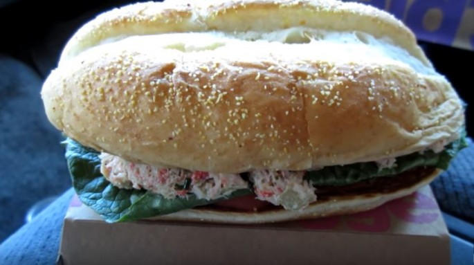 A McDonald's crab sandwich is placed on top its packaging for display. 