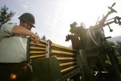  A staff member from Beijing's Xiangshan Weather Modification Practice Base equips a two-pipe cannon used for rain reduction and cloud dispersion with projectiles during a media presentation.