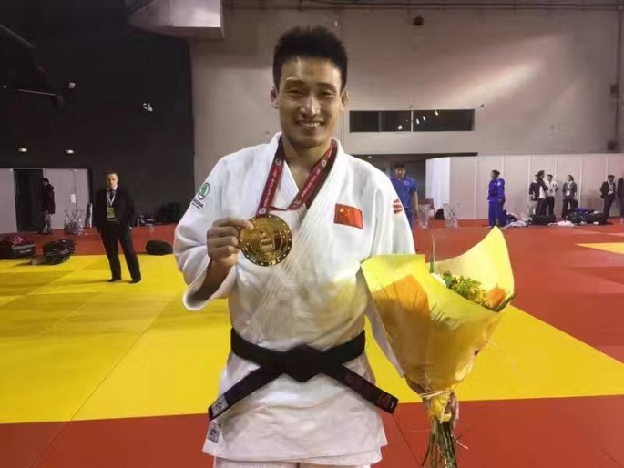Judoka Cheng Xunzhao showing his gold medal from the Paris Grand Slam.