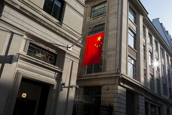 The Chinese national flag hanging in sunshine from the Bank of China's headquarters in the City of London, United Kingdom.