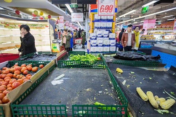 Shoppers pass by almost empty shelves in a supermarket in Hangzhou, East China's Zhejiang Province.