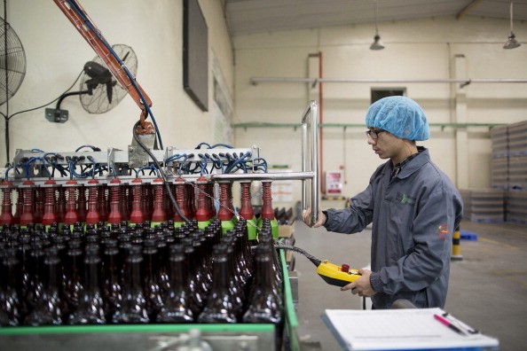 An employee seals bottles of Maggi seasoning on a machine at the Nestle Dongguan Ltd. factory in Dongguan, Guangdong Province.