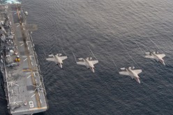 Four F-35B Lightning II aircraft perform a flyover above the amphibious assault ship USS America (LHA 6).                   