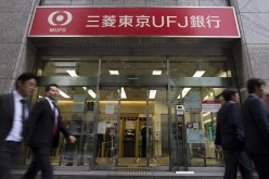 Pedestrians walk past a Bank of Tokyo-Mitsubishi UFJ Ltd. branch, a unit of Mitsubishi UFJ Financial Group Inc. (MUFG).