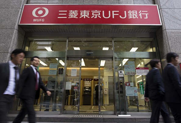 Pedestrians walk past a Bank of Tokyo-Mitsubishi UFJ Ltd. branch, a unit of Mitsubishi UFJ Financial Group Inc. (MUFG).