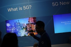 An attendee listens to information about 5G, aka 5th generation mobile networks, at the Qualcomm booth during CES 2017.