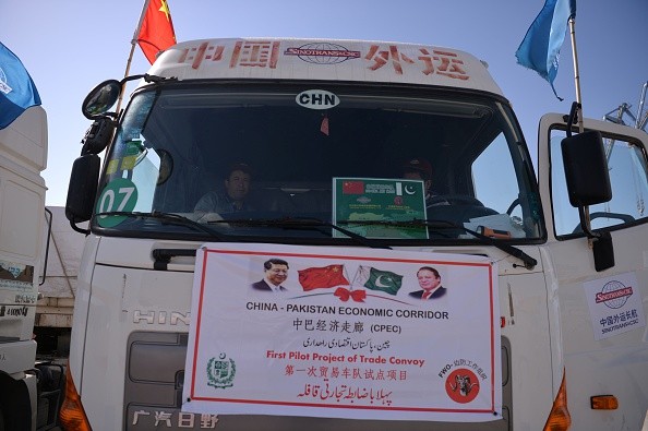 Chinese workers sit in trucks carrying goods during the opening of a trade project in Gwadar port, some 700 km west of the Pakistani city of Karachi.