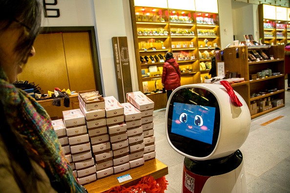 An AI robot is selling souvenir goods in a tourist shop. Besides introducing the information of goods, she can also interact and respond with voice appropriately with customers.