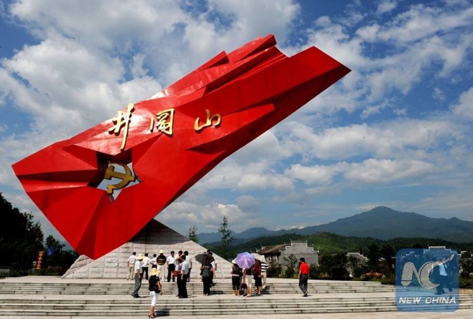 Tourists stand beside a monument to Communist partisans in Jinggangshan, Jiangxi Province, China.