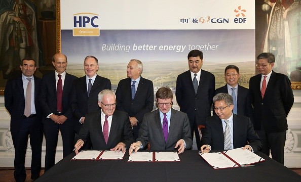 EDF Group CEO Jean-Bernard Levy, Britain's Business Minister Greg Clark, and China General Nuclear Corporation (CGN) Chairman He Yu, swap paperwork as they attend a signing ceremony in London.