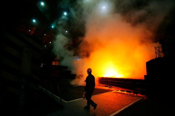 A worker walks past a furnace at a Shanghai Baosteel Group factory, Jan. 15, 2007 in Shanghai, China.