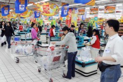 Chinese shoppers stand at the check-out counters inside a Carrefour supermarket store in the Gubei district of Shanghai.