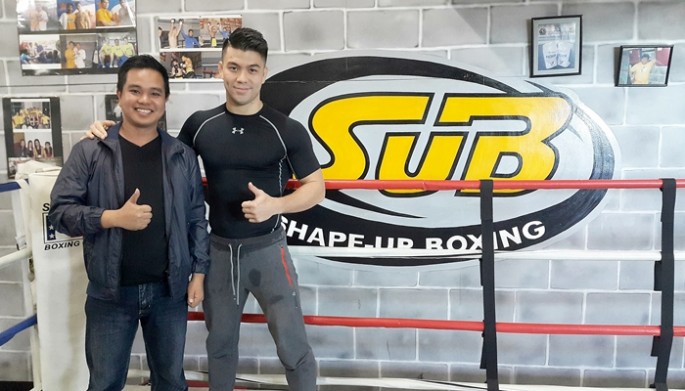 Filmmaker Conan Altatis poses with MMA fighter Mark Striegl in Shape-Up Boxing Gym in Baguio City, Philippines.