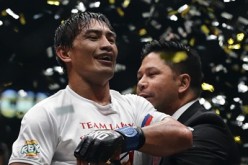 Eduard Folayang receives the championship belt from One FC CEO Victor Cui after defeating Shinya Aoki for the men's lightweight world championship bout during 'One Championship: Defending Honor' on Nov. 11, 2016 in Singapore.