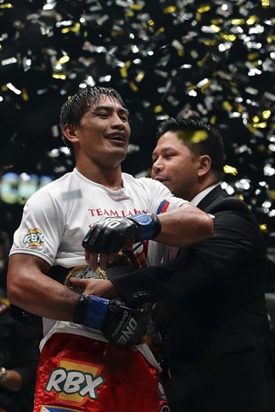 Eduard Folayang receives the championship belt from One FC CEO Victor Cui after defeating Shinya Aoki for the men's lightweight world championship bout during 'One Championship: Defending Honor' on Nov. 11, 2016 in Singapore.