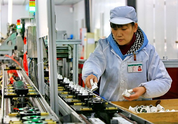 Chinese employees working on an energy-saving bulb production line at a lighting factory in Suining, southwest China's Sichuan Province.