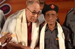 Tibetan spiritual leader the Dalai Lama (L) shakes hands with retired Assam Rifles personnel Naren Chandra Das.