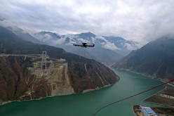 A drone towing a cable flies over the Dadu River to another side of the Ya'an-Kangding expressway bridge being built on Dec. 20, 2016 in Ya'an, Sichuan Province of China.