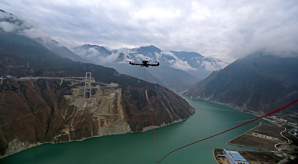 A drone towing a cable flies over the Dadu River to another side of the Ya'an-Kangding expressway bridge being built on Dec. 20, 2016 in Ya'an, Sichuan Province of China.