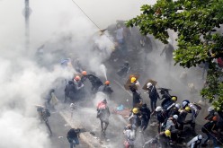 Tear gas and fire extinguisher gas float around demonstrators during a protest against the military coup in Yangon, Myanmar,