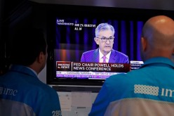  Traders look on as a screen shows Federal Reserve Chairman Jerome Powell's news conference 