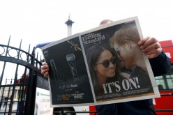 A person is seen reading the London Evening Standard with the news that Prince Harry has announced his engagement to Meghan Markle,