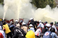 Tear gas and fire extinguisher gas float around demonstrators during a protest against the military coup in Naypyitaw, Myanmar, 