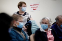 People, wearing protective face masks, wait to receive the AstraZeneca COVID-19 vaccine at the Clinique de l'Estree - ELSAN