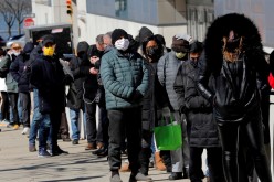 People wait in a line stretching around the Jacob K. Javits Convention Center on midtown Manhattan's west side, 