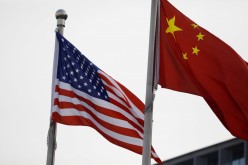 Chinese and U.S. flags flutter outside the building of an American company in Beijing,