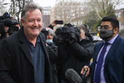 Journalist and television presenter Piers Morgan smiles in front of members of the media as he takes his daughter Elise to school, 