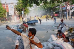 A man uses a slingshot during the security force crack down on anti-coup protesters in Mandalay,