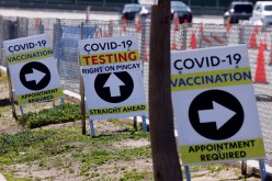 Signs guide the public at a large vaccination and testing site as people with preexisting health conditions 