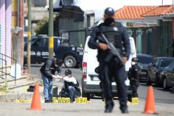 Police officers work at a crime scene where gunmen killed at least 13 Mexican police officers in an ambush, in Coatepec Harinas, Mexico