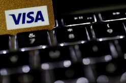 A Visa credit card is seen on a computer keyboard in this picture illustration taken