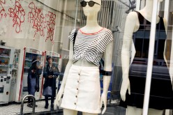 People stand next to the window of a fashion boutique in a shopping district in Tokyo, Japan,